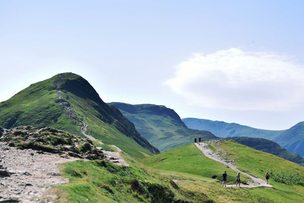 hikers walking along ridge path in UK countryside hills clear weather