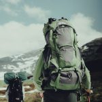 a man carrying a green backpack