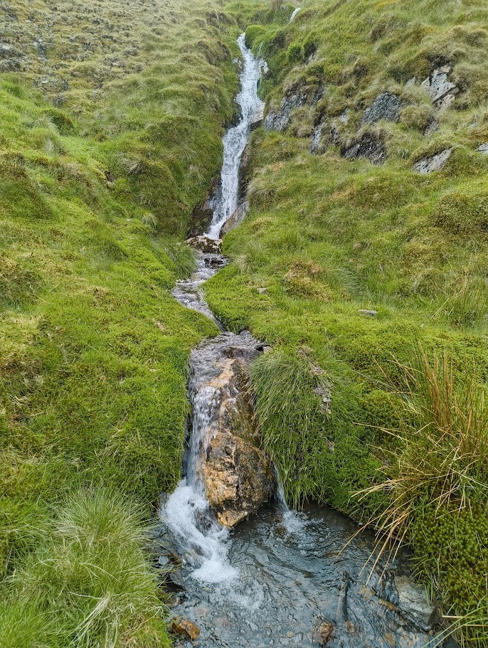 clear mountain stream used as a water source while hiking in the UK