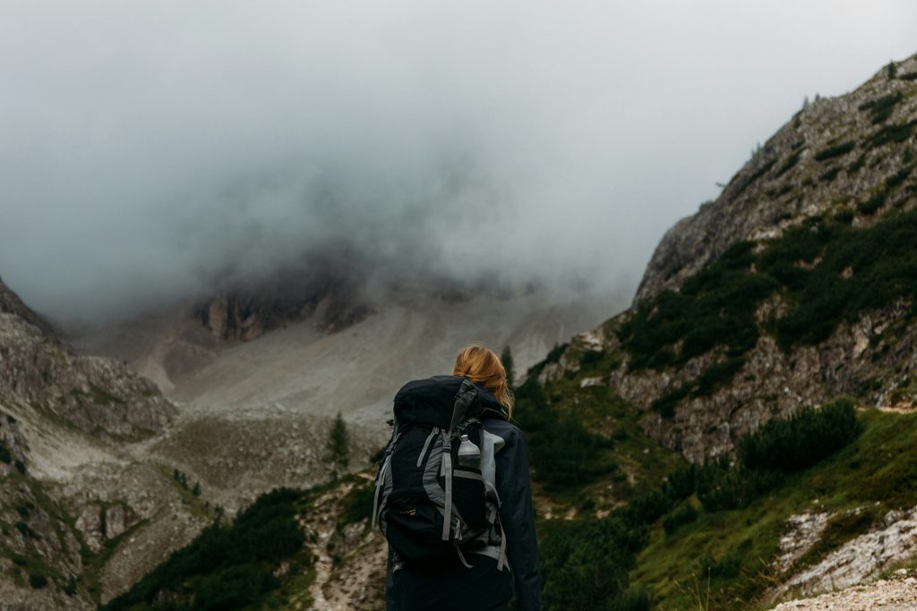hiker with backpack walking in misty mountain landscape UK