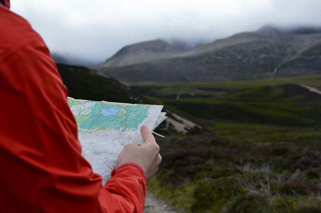 hiker reading a map while hiking in the UK countryside