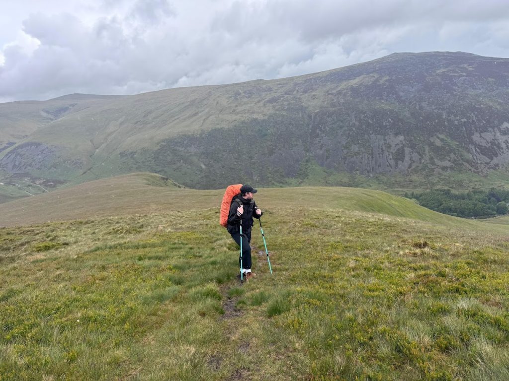 hiker using trekking poles on a mountain hiking trail