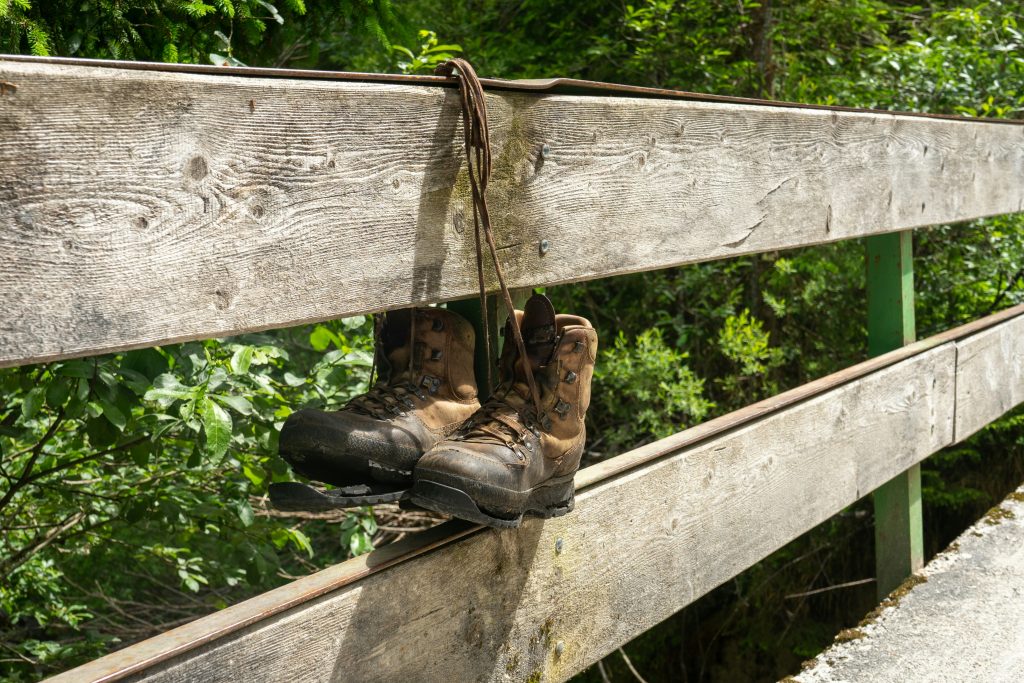 worn hiking boots with muddy soles after a long hike