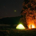 people camping near trees during night time