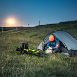 a man sitting on the tent near his bike