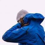 person wearing blue hoodie jacket with gray knit hat