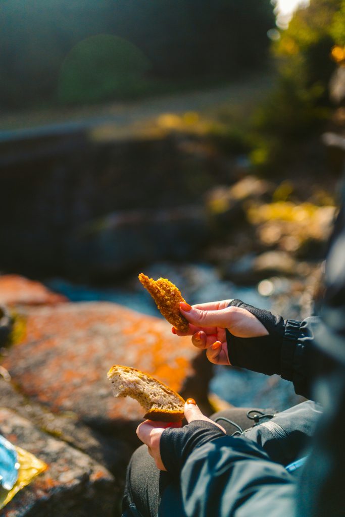 Hiker eating a snack during a rest break on a hiking trail