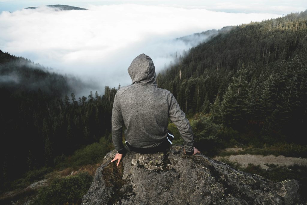 Hiker wearing a hoodie in cold misty forest conditions during a hike