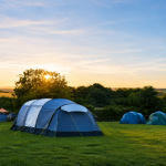 Tents pitched on a campsite at sunset